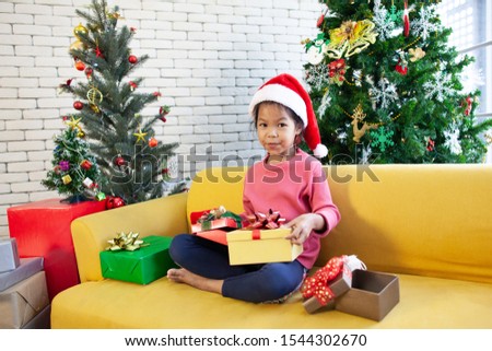 Cute asian child girl surprise with gift and holding beautiful gift in hand on Christmas celebration
