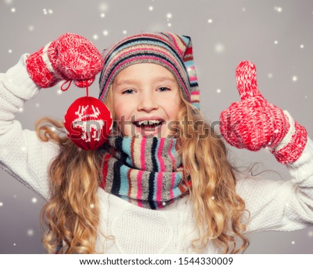 Girl in winter clothes. Happy child. Studio shot