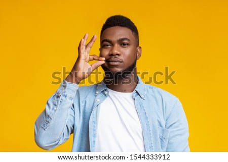 Keeping quiet concept. Attractive african american guy zipping his mouth shut, promising not to tell secret on yellow background Royalty-Free Stock Photo #1544333912