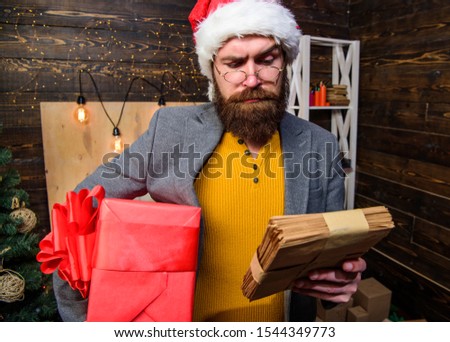 Man bearded hipster wear santa hat hold bunch of letters and gift box. Gifts delivery service. Letter for santa claus. Man mature bearded with eyeglasses received post for santa. Post for santa claus.