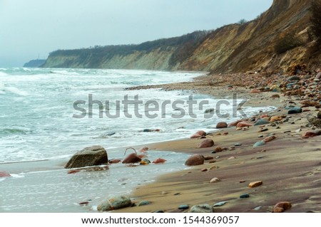 stormy sea in winter and autumn, rocky seashore and high cliff