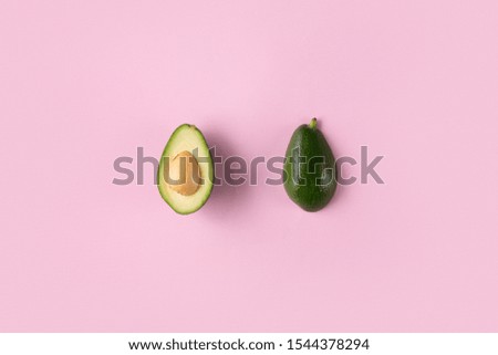 Avocado halves isolated on pink background top view