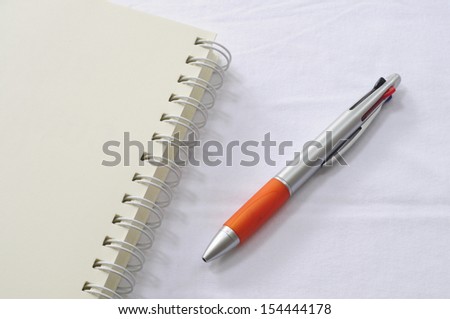 Notebook with pen on white background 