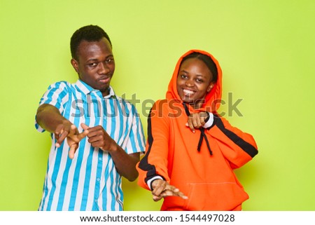 African-Americans on a green background are having fun and gesturing with their hands