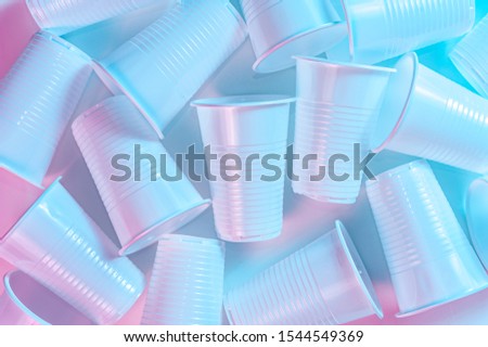 disposable plastic tablewar on a light background in pastel colors. Minimalistic ecologically clean still life. Pop Art. And ecology problem concept.