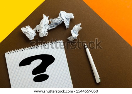 Question mark on notebook with crumpled sheet paper 
