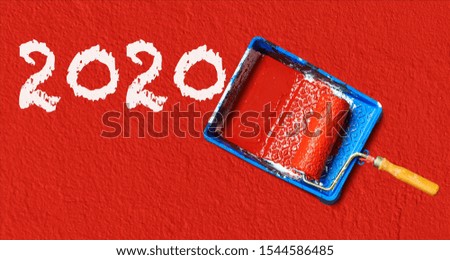 Painting tools and 2020 text on red wall. Happy New Year

