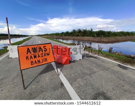 road closure with a " danger, flood area" sign due to flood