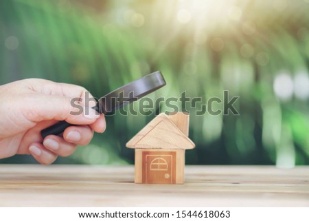 Wooden houses and magnifying glass. Property valuation. Home appraisal. Choice of location for the construction. House searching concept. Search for housing and apartments. Real estate