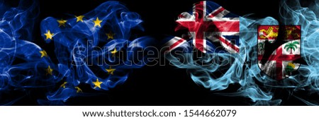Eu, European union vs Fiji smoke flags placed side by side. Thick colored silky smokes abstract flags 