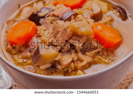 Healthy turkey and rice soup,served in a white bowl.