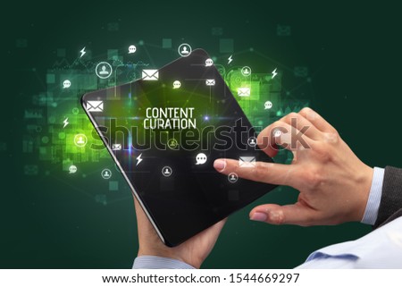 Businessman holding a foldable smartphone with CONTENT CURATION inscription, social networking concept