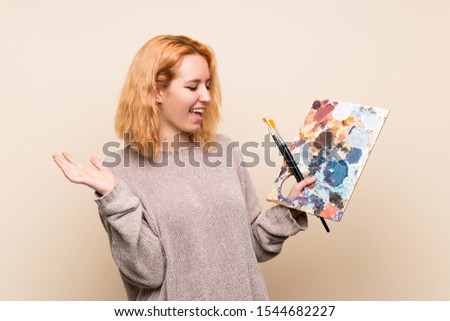 Young artist woman over isolated background with surprise facial expression