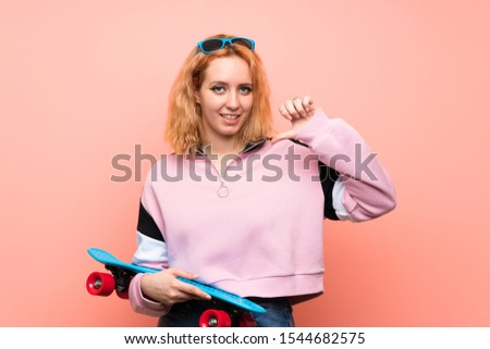Young skater woman over isolated pink background proud and self-satisfied