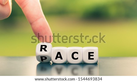 Hand turns a dice and changes the word "race" to "pace". Royalty-Free Stock Photo #1544693834