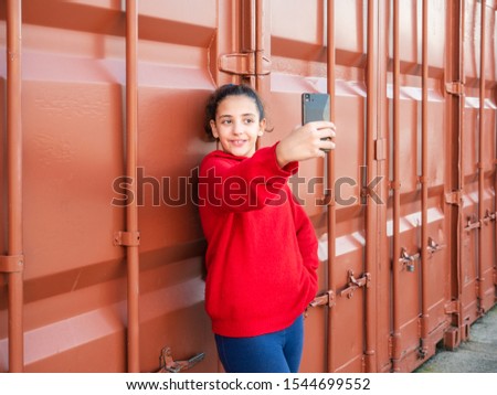 young girl with a smart phone doing a selfie, isolated, copy space