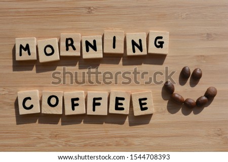 Morning Coffee. Words in 3d wooden alphabet letters with coffee beans on  bamboo wood background.