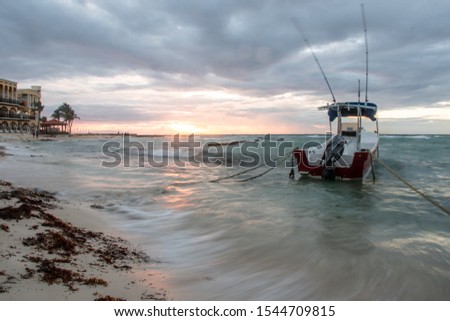 A boat drifts along the early morning waters as the sun rises for a new morning. This picture is a long exposure showing the movement of the waters in the gulf of Mexico. 