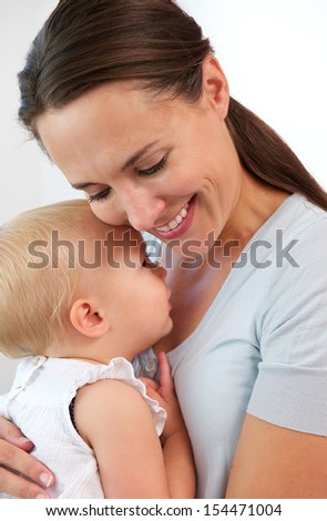 Closeup portrait of a smiling mother hugging cute baby girl
