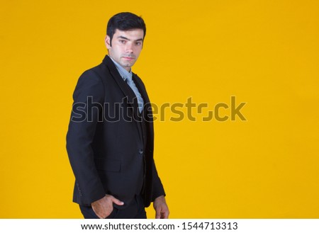 Young handsome businessman wearing suit  over isolated yellow background 