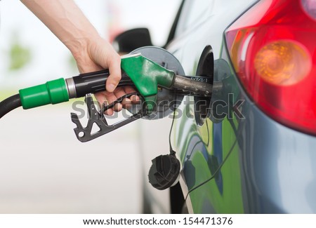 transportation and ownership concept - man pumping gasoline fuel in car at gas station Royalty-Free Stock Photo #154471376