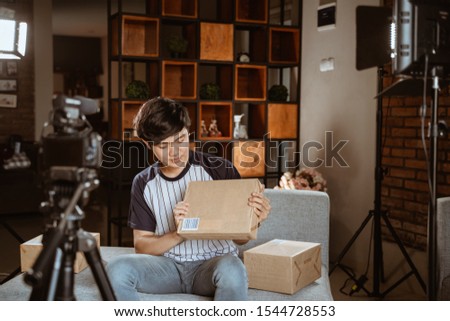 asian young man vlogger recording new vlog about unboxing review when work at home