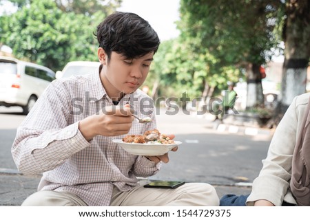 portrait of man enjoy eat traditional food of indonesia is nasi rames on the tikar