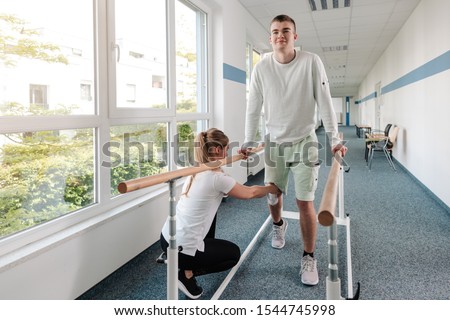 Young man in walking rehabilitation course after a sport injury on his knee Royalty-Free Stock Photo #1544745998
