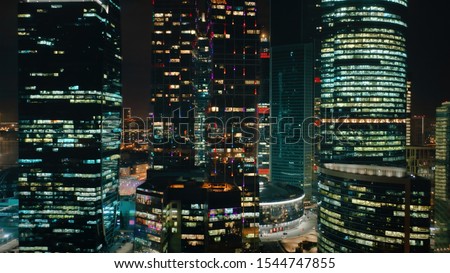 Amazing close up view from above to Moscow City Business Center on the night. Camera slowly moves around the skyscrapers from right to left showing their bright glittering lights and modern beauty.