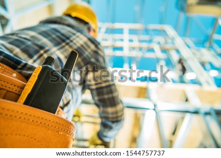 Construction Site Communication. Walkie-Talkie Radio Device in Contractors Tools Belt. Closeup Photo.