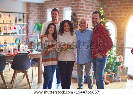 Beautiful family smiling happy and confident. Standing and posing with tree celebrating Christmas at home
