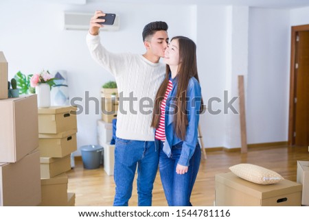 Young asian couple smiling taking a selfie photo with smartphone, moving to a new home together