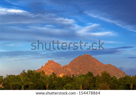 Looking across vivid green trees at Camelback Mountain against a deep blue sky.  Phoenix, Arizona, USA. Royalty-Free Stock Photo #154478864