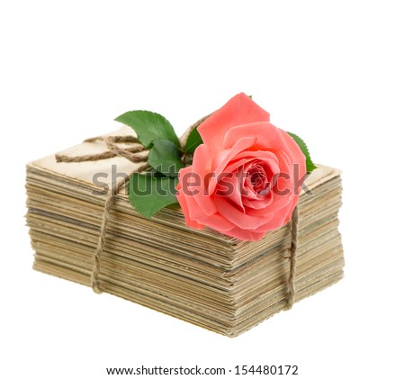 Stack of old love letters and postcards with pink rose flower isolated on white background. Nostalgic sentimental picture