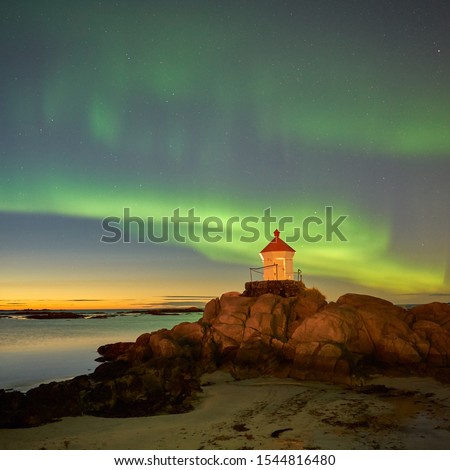 The northern lights swing like curtains in the wind. This lights up green. In the picture is also a beautiful lighthouse to discover.