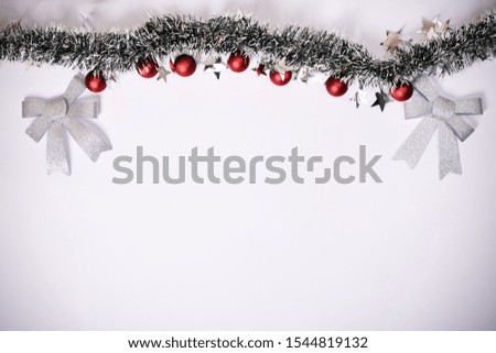 Christmas composition. Garland with red balls, stars and glittery bows on white background. Christmas, winter, new year concept. Flat lay, top view, copy space.