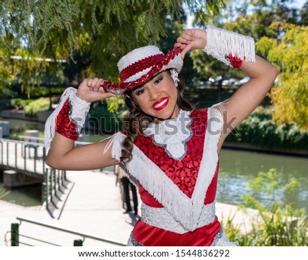 
Young and beautiful Hispanic high school girl in her school dance uniform posing for school pictures