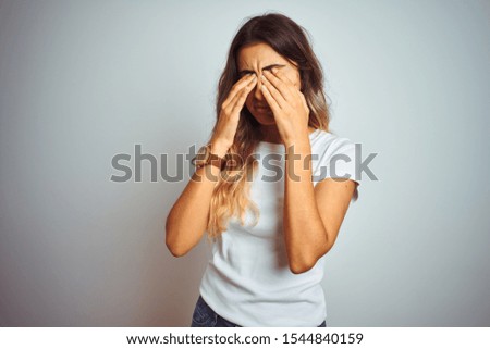 Young beautiful woman wearing casual white t-shirt over isolated background rubbing eyes for fatigue and headache, sleepy and tired expression. Vision problem