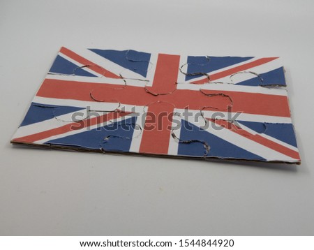 Jigsaw puzzle with picture of British flag put together in front of white background