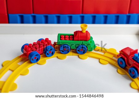 Plastic  toy trailer on a white table, background for children's additional education and leisure and early development, train travel, railroad game