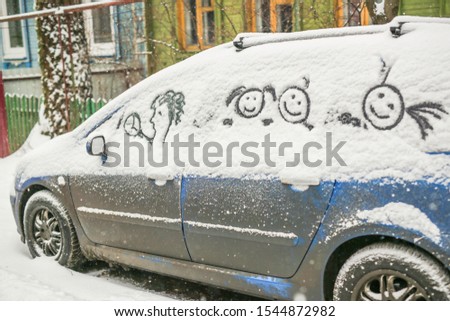 Dirty car in the snow on a village street, funny pictures in the snow by car