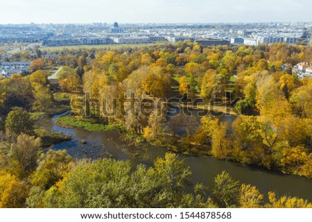 Beautiful river view with autumn trees. Drone flies along a river with yellow trees. Warsaw. Poland. Epic aerial flight over water. Colorful autumn trees in the daytime. Drone Shot 4K.