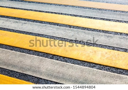 Pedestrian crossing with white and yellow stripes close up