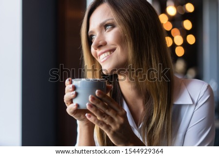 Portrait of happy brunette woman drinking coffee in the morning at restaurant