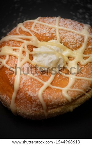 isolated fresh donut in italian breakfast with sugar, chocolate and cream on black background