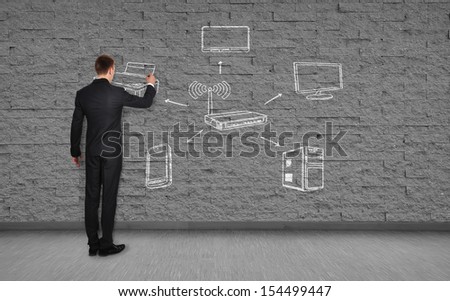 businessman drawing wi-fi scheme  on brick wall