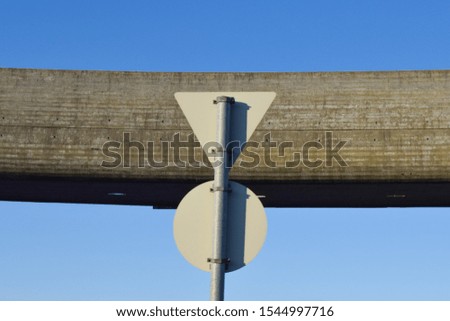 Road sign in front of a bridge against a blue sky. Geometry bridge.