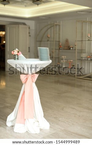 Concierge table for a wedding ceremony, decorated with pink fabric. Holiday Decor.