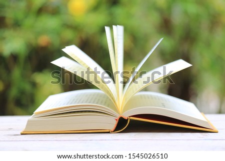 Close-up of open books on wooden tables in the garden selective focus and shallow depth of field