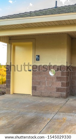 Vertical frame Exterior of a public restroom with men women and handicaped signs on the wall